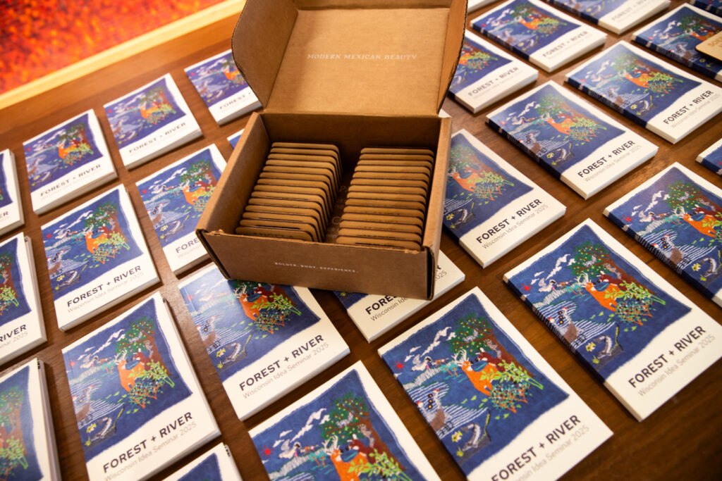 12 May, 2025.

A box of wooden nametags---reusable and when the time ever comes, compostable--organized alphabetically by first name, await distribution at the 2025 Wisconsin Idea Seminar orientation at One Alumni Place in Madison. Participants of the FOREST + RIVER journey would wear the nametags throughout the five-day experience, and many choose to continue affixing the nametag at future campus events and meetings. (Photo by Catherine Reiland / UW-Madison)